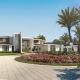Luxury residential custom home front view. Includes the driveway and fountain with red flowers